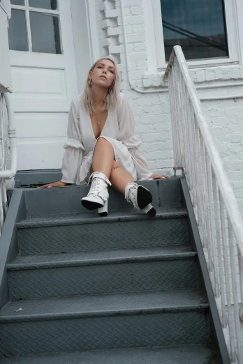 a woman is sitting down on a step wearing shoes