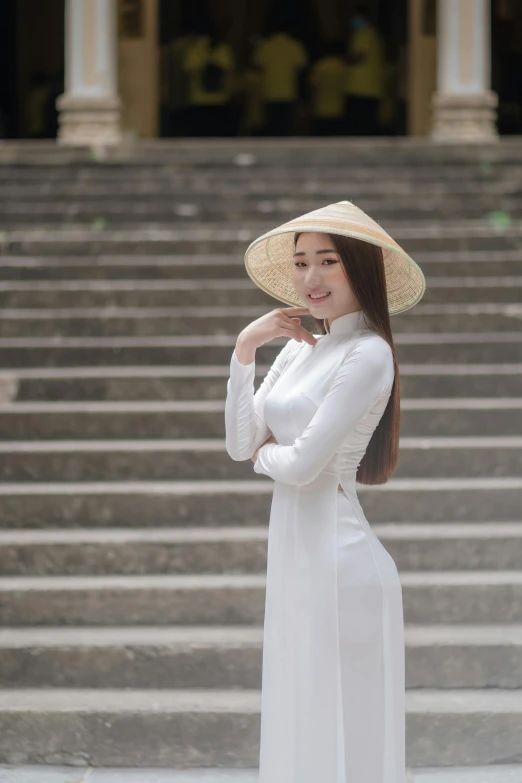 a girl is standing outside in a dress and hat