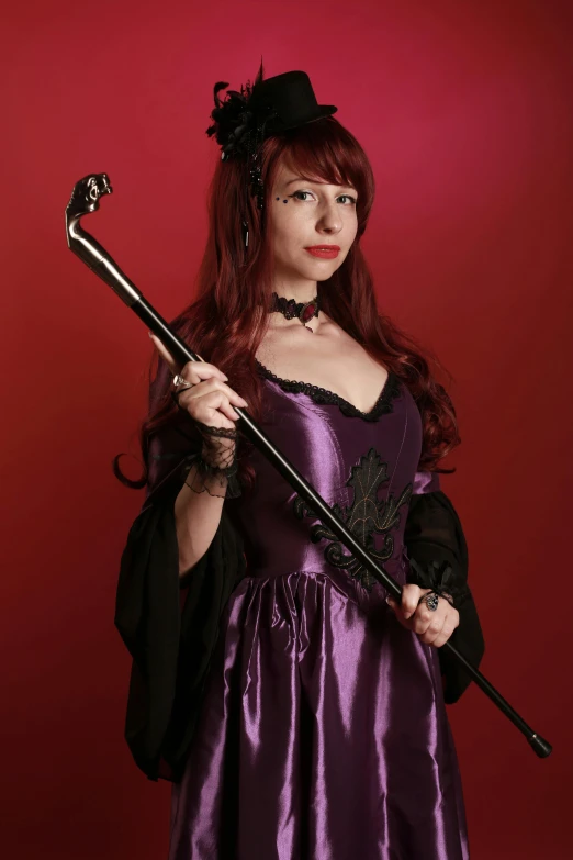 a woman dressed in purple holding a wand