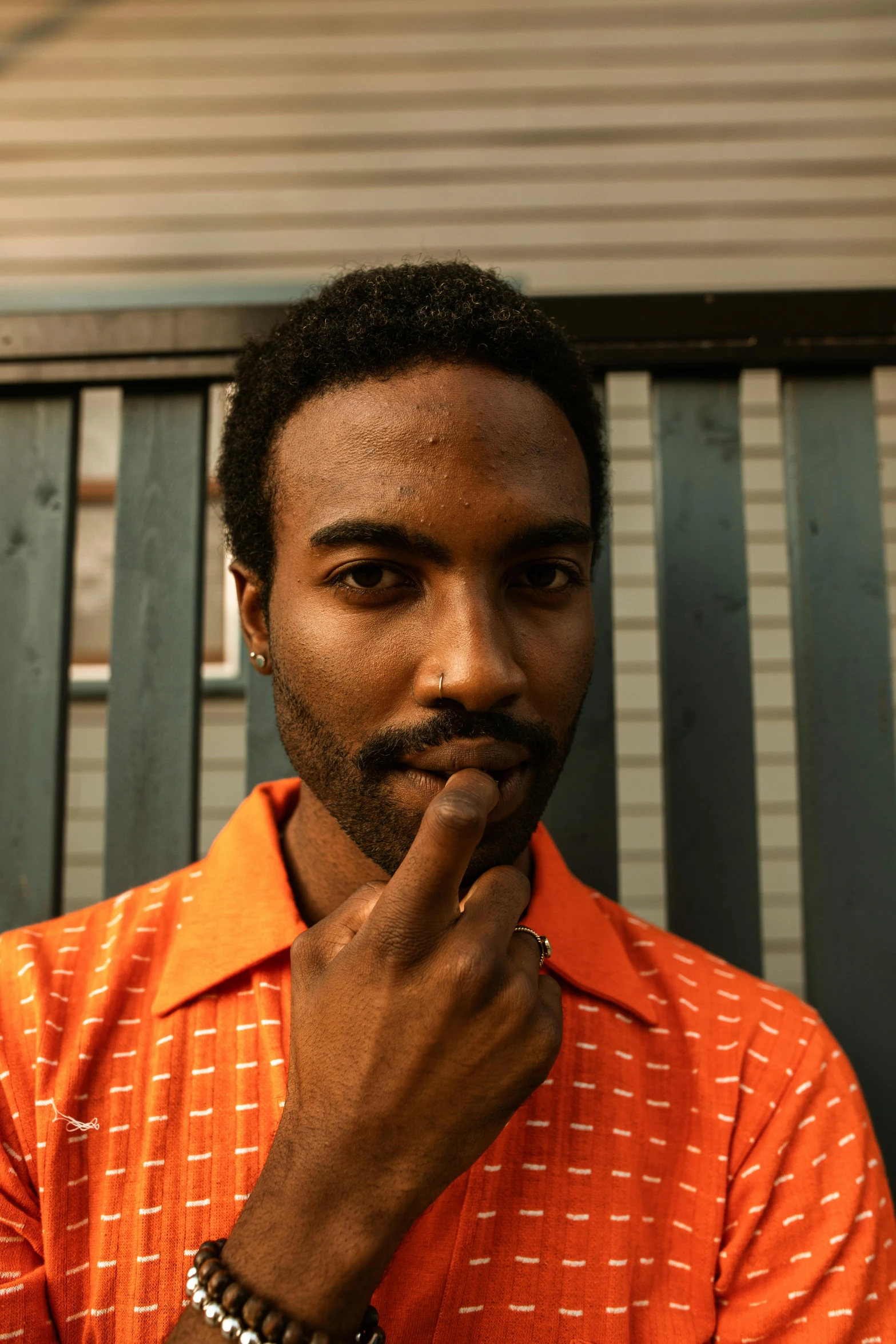 a man in an orange shirt stares to his left