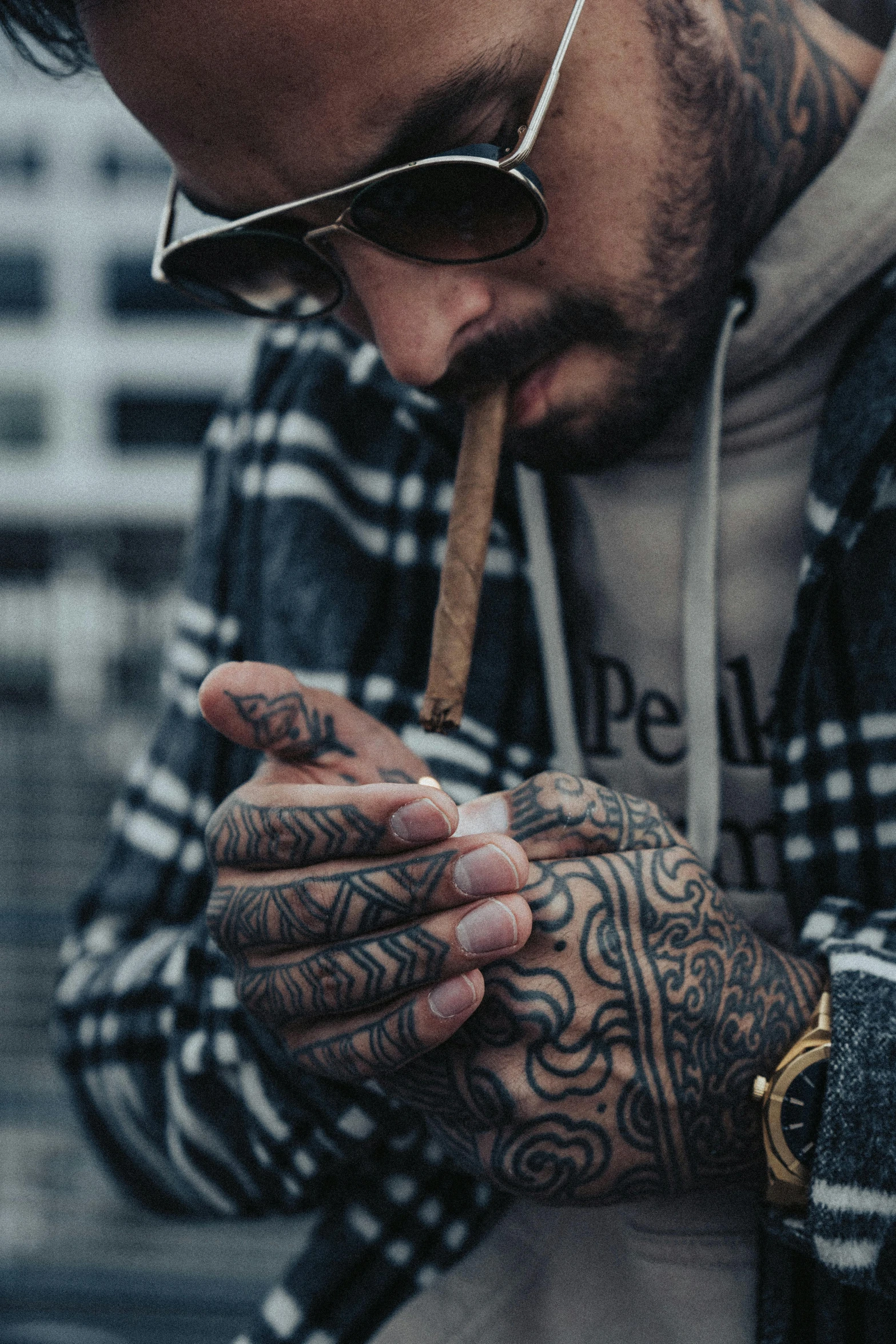 man smoking a cigarette outside while wearing sunglasses