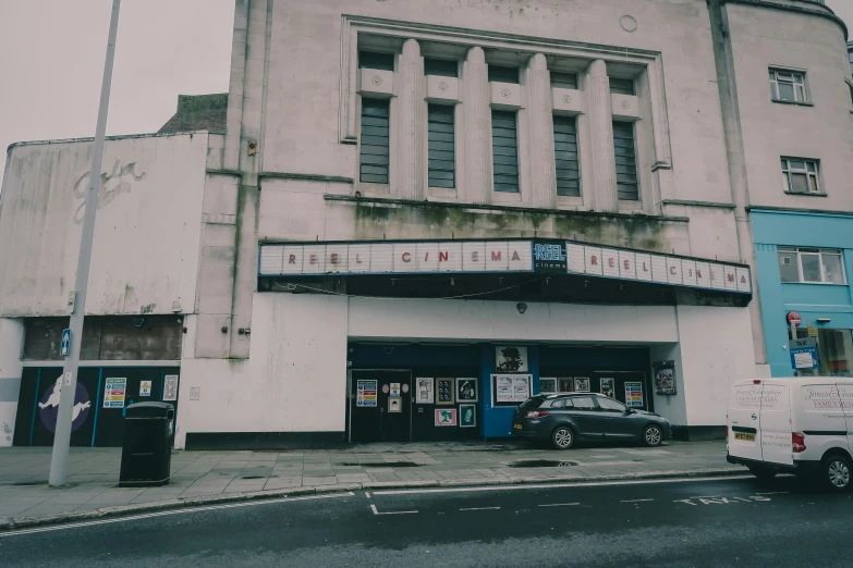 an old theatre building sitting on the side of a street