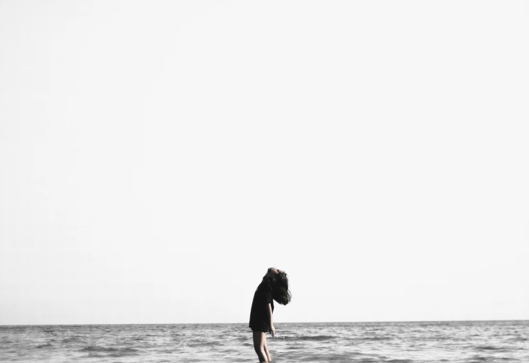 a person with an umbrella walking along the water