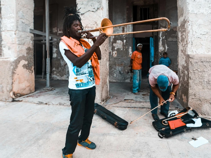 a person playing on a trumpet in front of a building