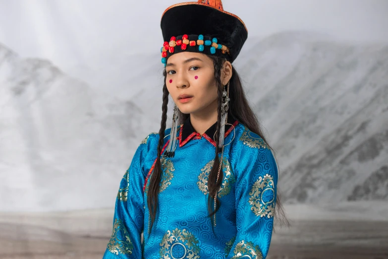 an ethnic woman in the mountains with long ids and a blue dress