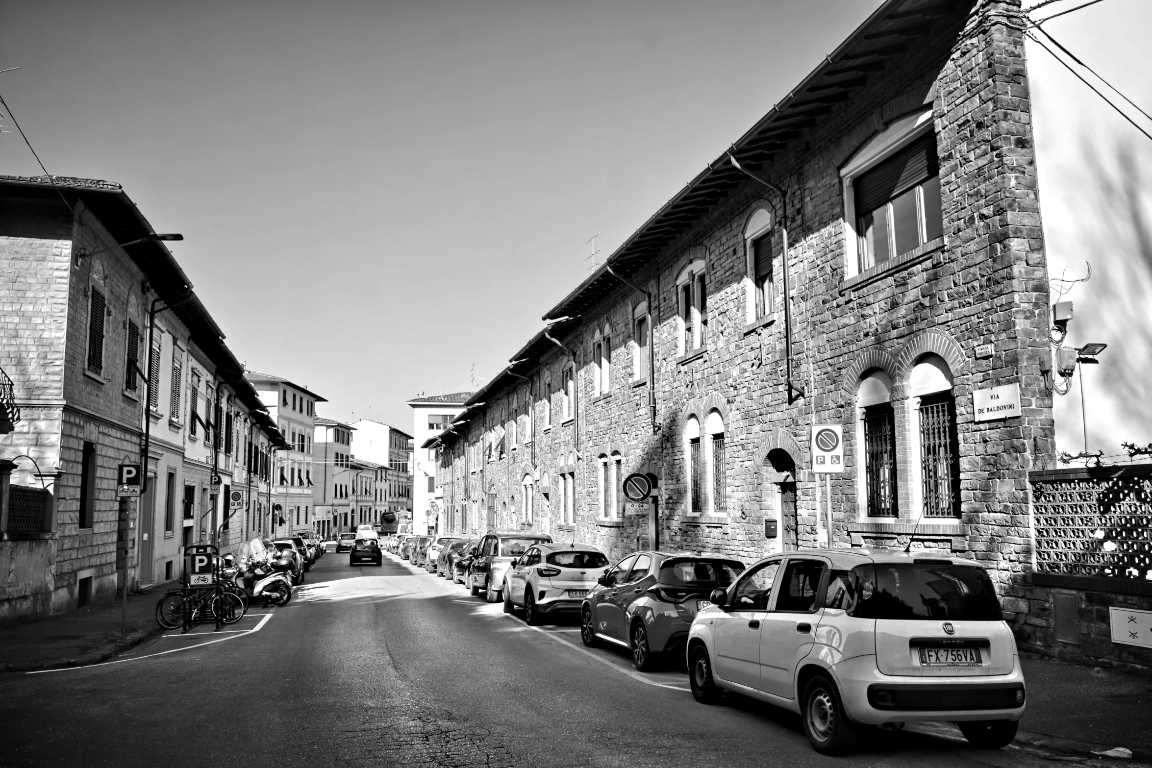 a black and white po of the street where cars are parked