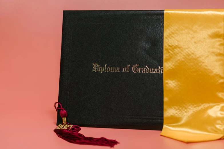 an graduation book sitting next to a golden and black tasseled tass