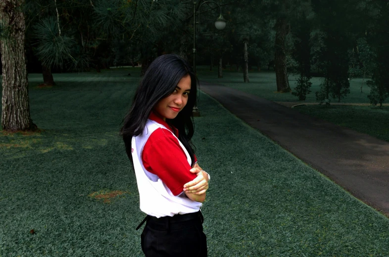 girl in red and white shirt standing on the grass