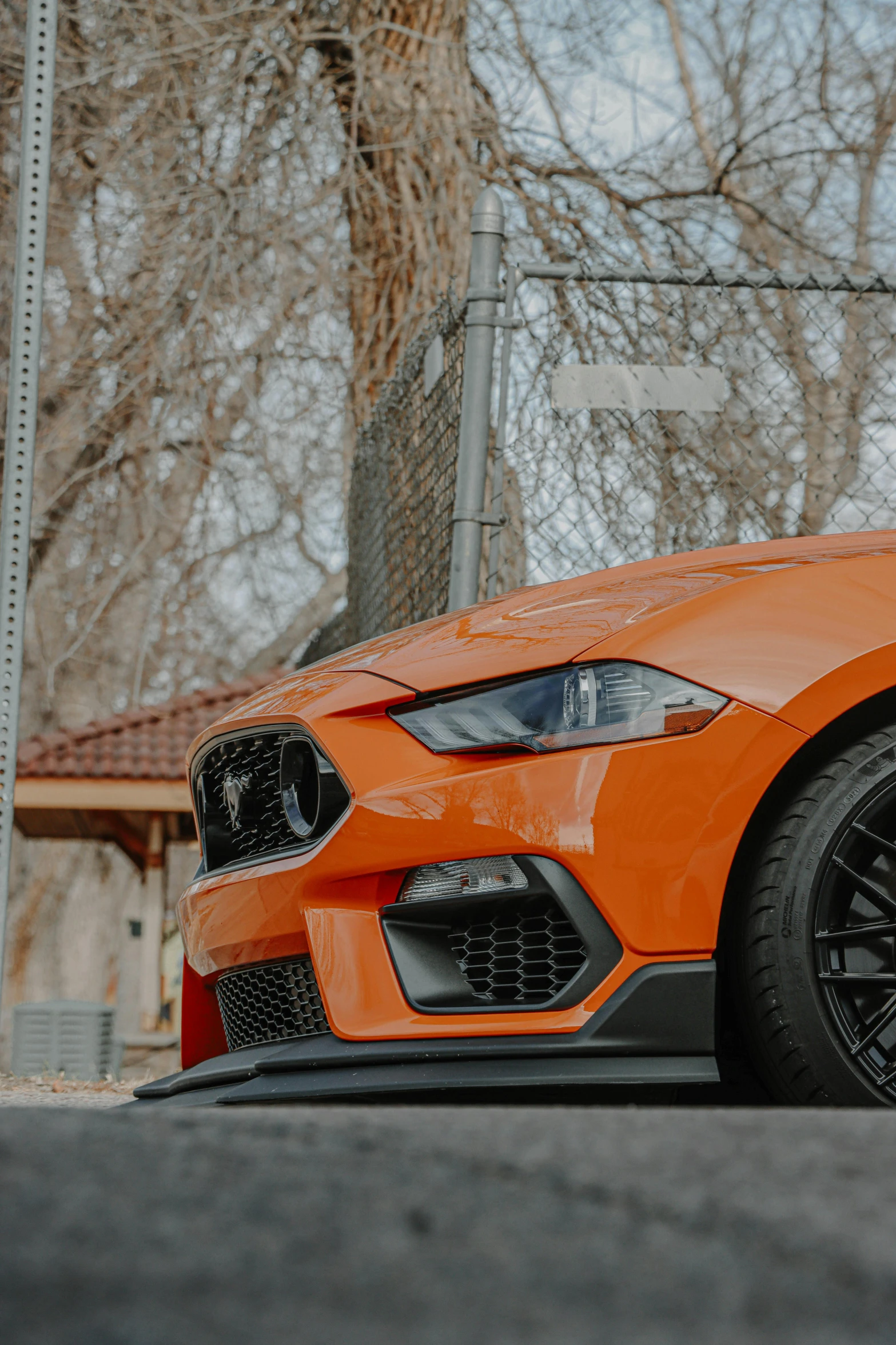 a bright orange bmw is parked in front of a building