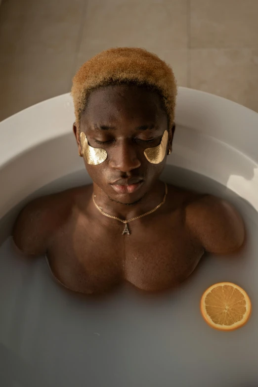 young african male in  tub with golden masks