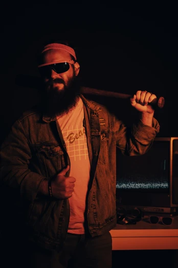 a man in sunglasses is holding a bat and a video game console
