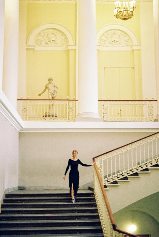 a woman walking down some stairs with her hand in the air