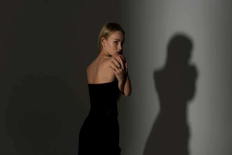 a women standing in front of a shadow of a man