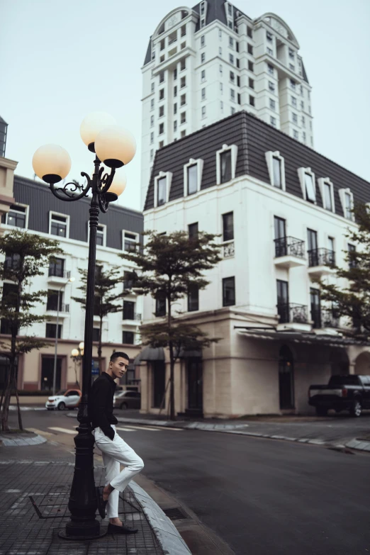 two people standing on a street next to a lamp