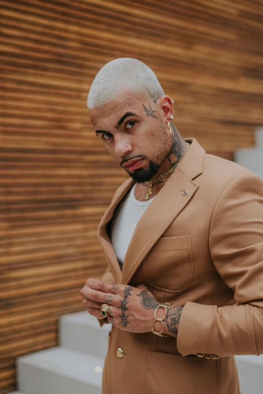 a man with tattoos is standing in front of stairs