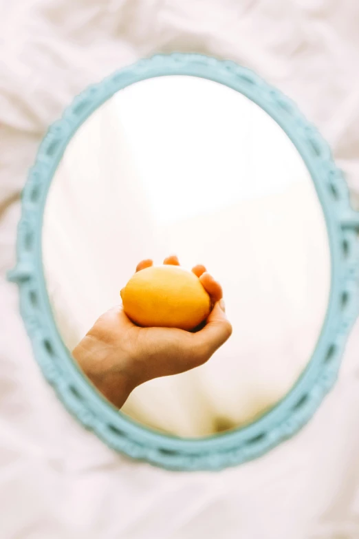 someone holding a donut in front of the mirror