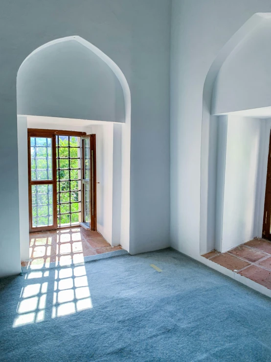 a room with two open windows and large blue carpet