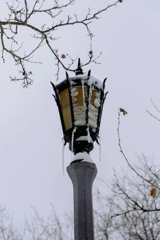 a light post covered in some snow during winter