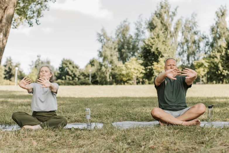 a man and woman are doing yoga outside