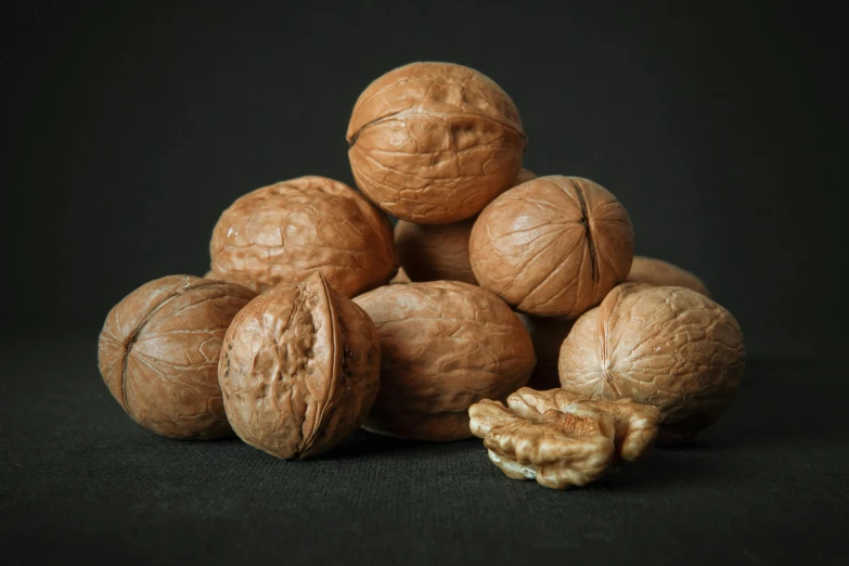 a pile of walnuts with some nuts out side