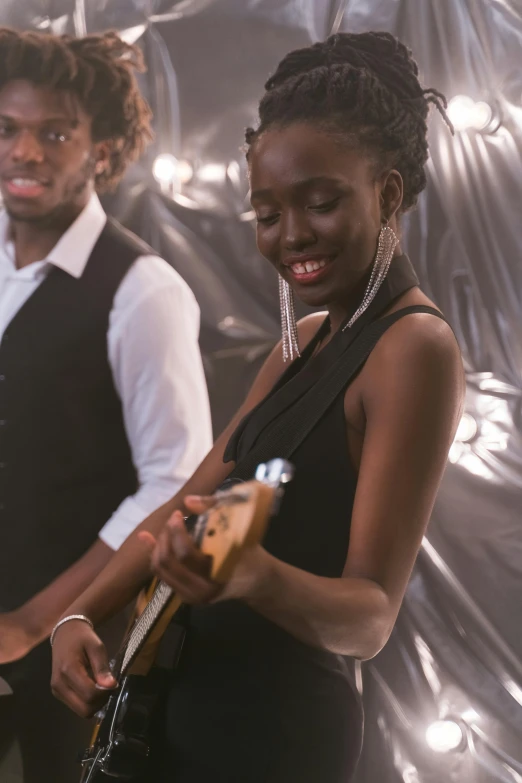 a black woman and a man playing guitars