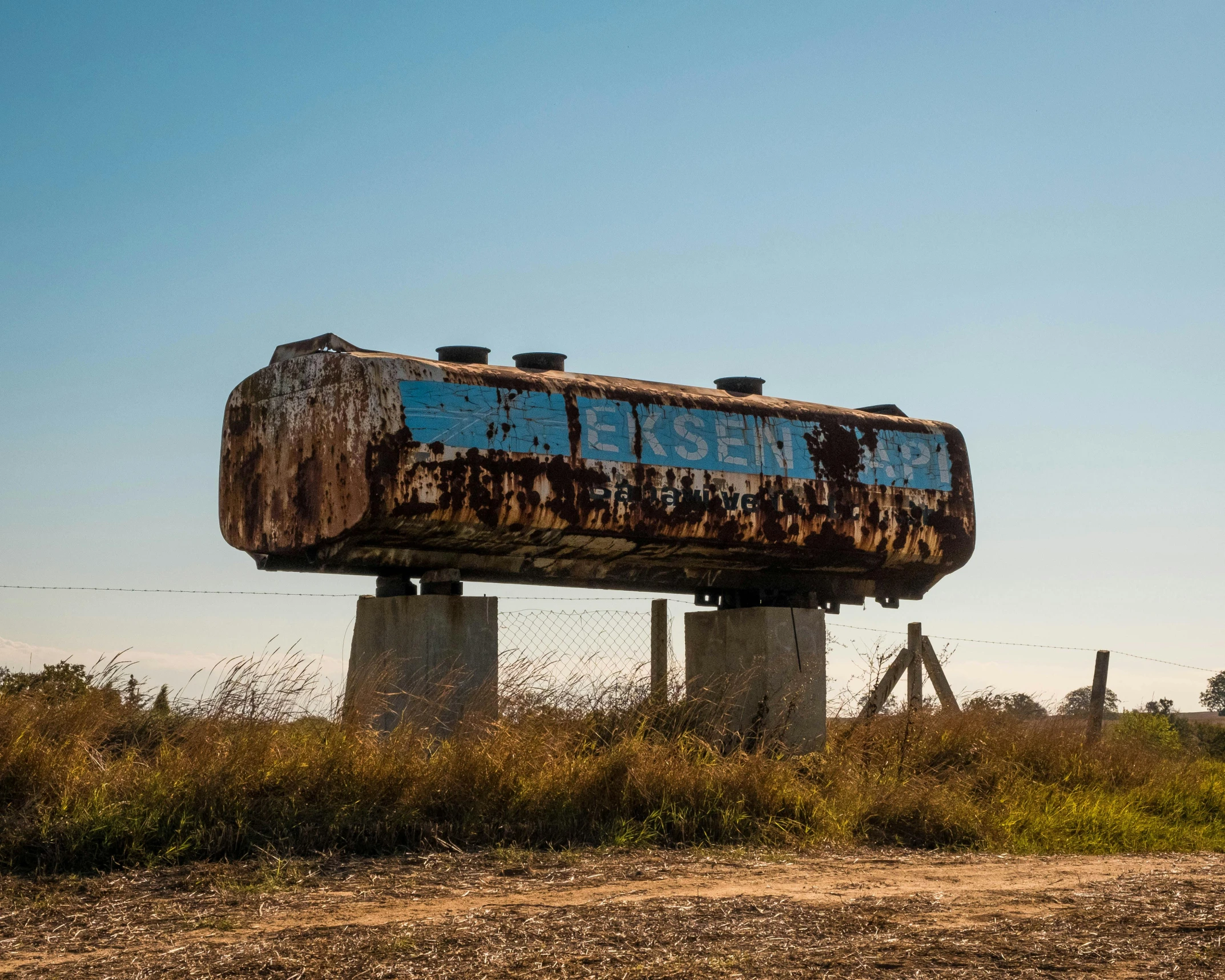 an old rusty train on the top of some columns