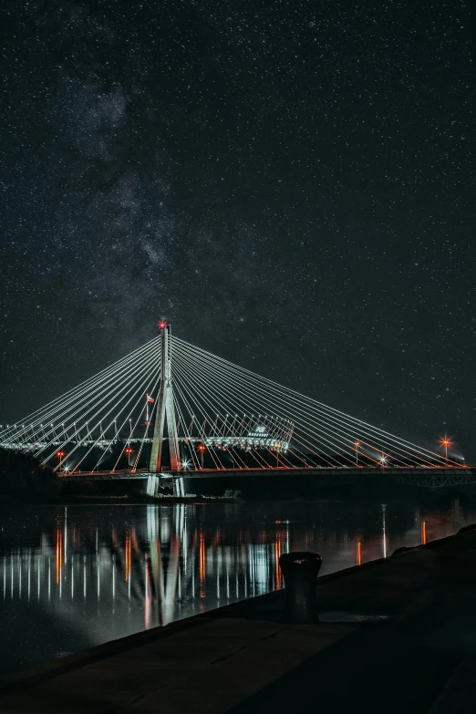 a very long bridge over water at night