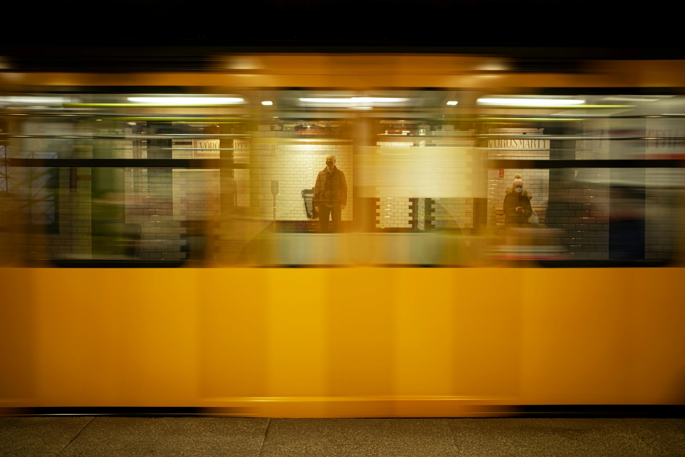 a man sitting in a subway waiting for the next train