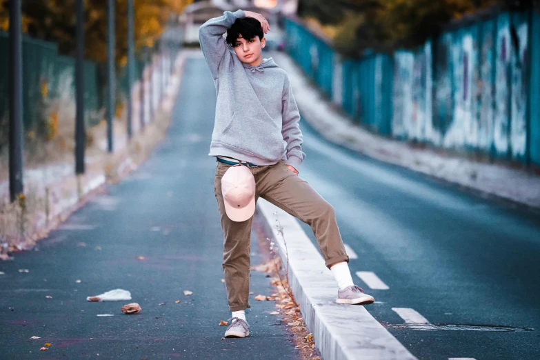 boy stretches on concrete wall with his feet up