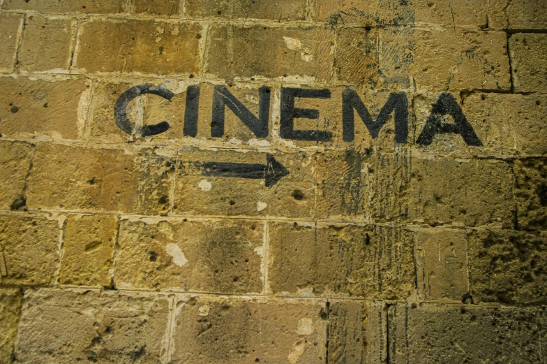 a po of an old wall with the word cinema painted on it