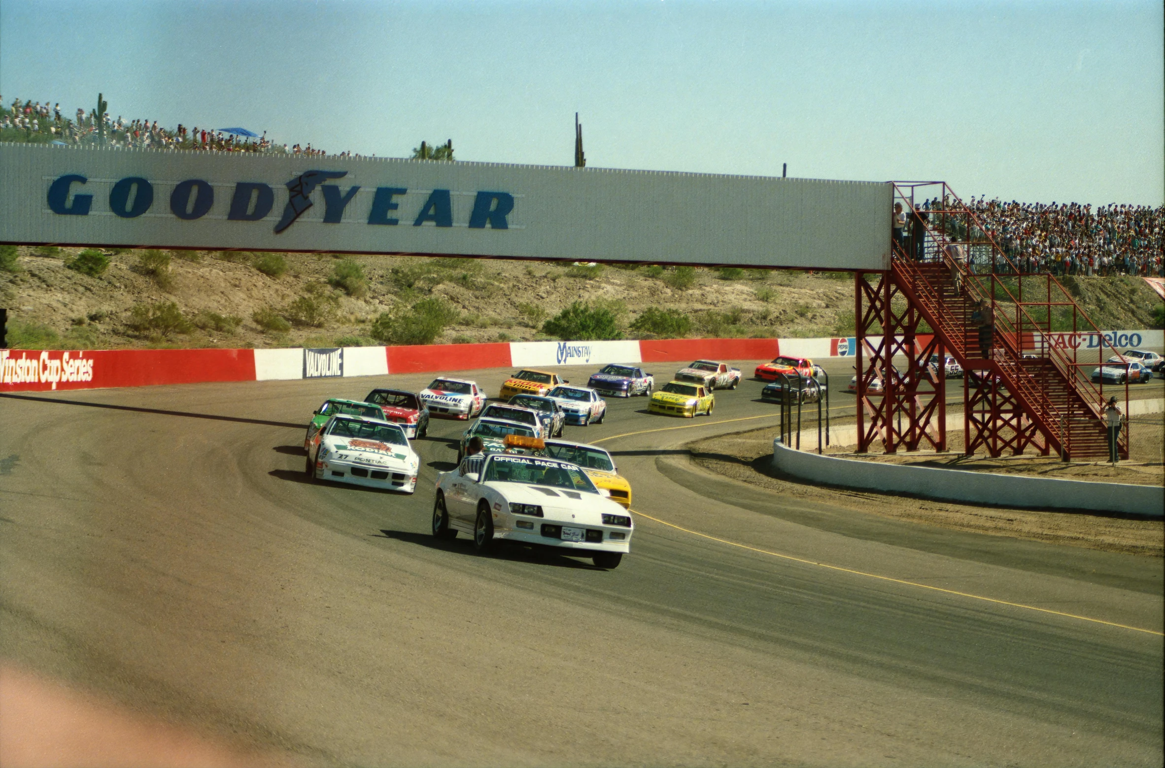 a row of race cars driving on top of a track