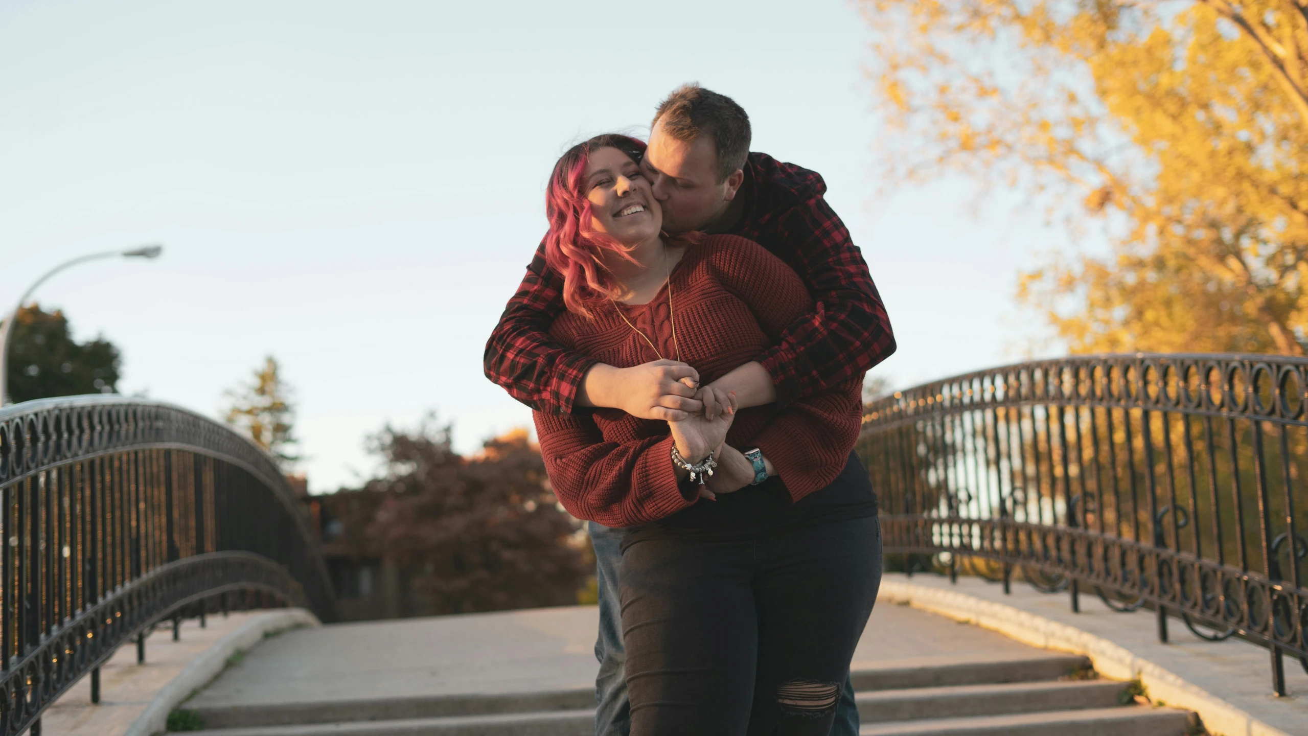 a couple is cuddling outside by some steps