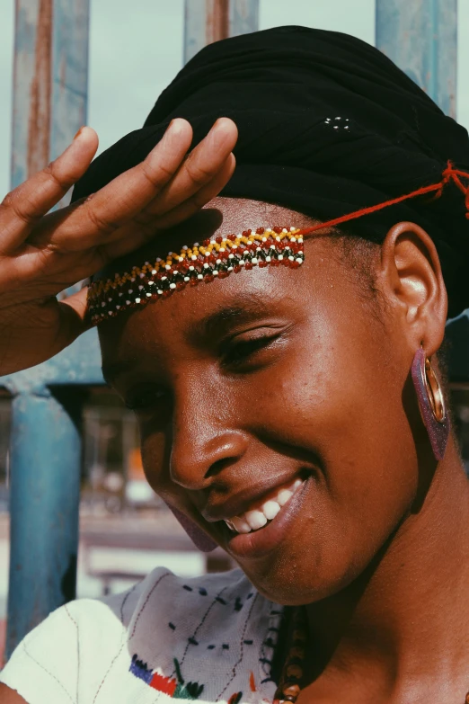 the girl smiles for the camera as she adjusts her head piece