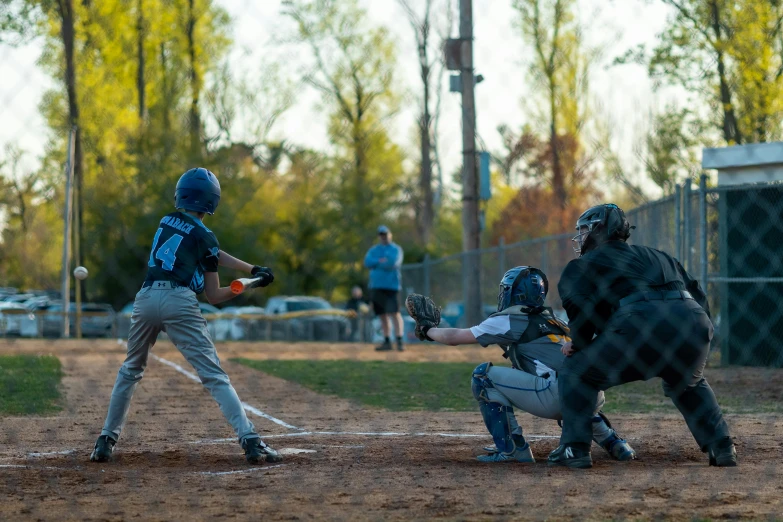 young baseball player swinging a bat on a field