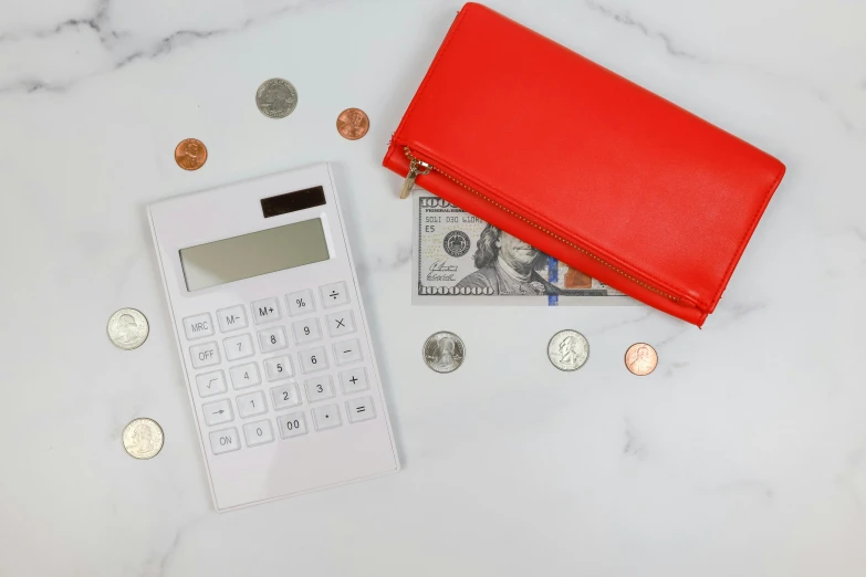 a red wallet, a calculator and two american coins