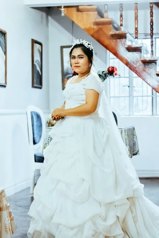 a  dressed in a white gown and posing for a picture