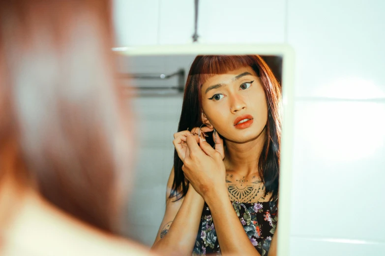 an asian girl who is putting her make up on