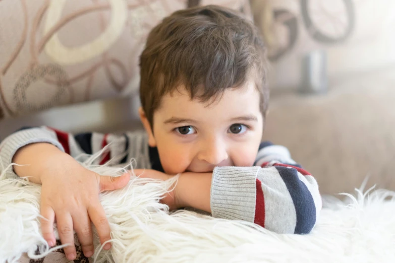 a  laying on a couch holding his hand over his shoulder