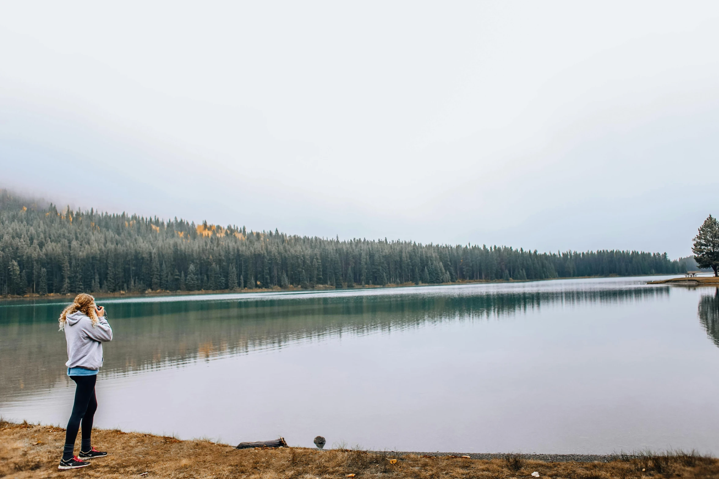 a person standing by a lake looking at the water