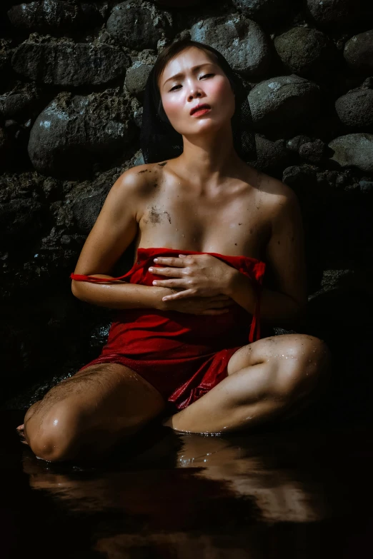 a young women in a red robe sitting on a water surface