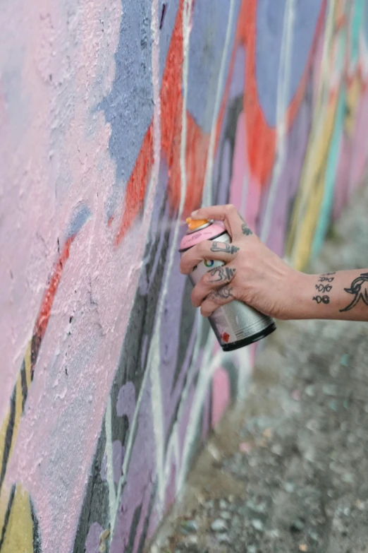 a person painting on the side of a building with a spray bottle