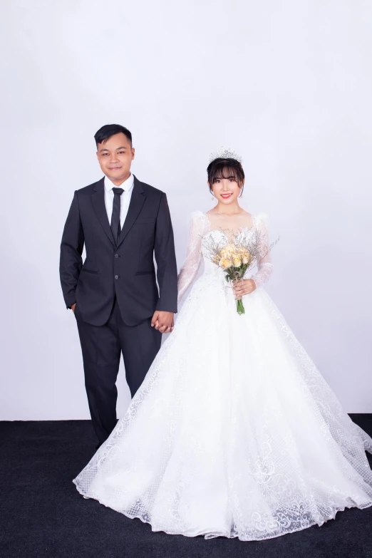 a bride and groom in wedding suits stand on a carpet