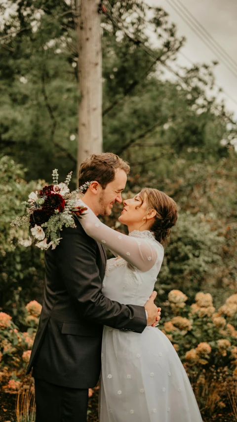 bride and groom holding each other for a kiss outside