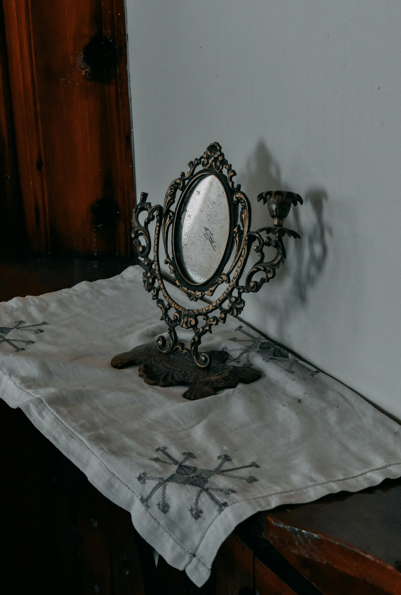 an antique looking mirror sits on top of a towel