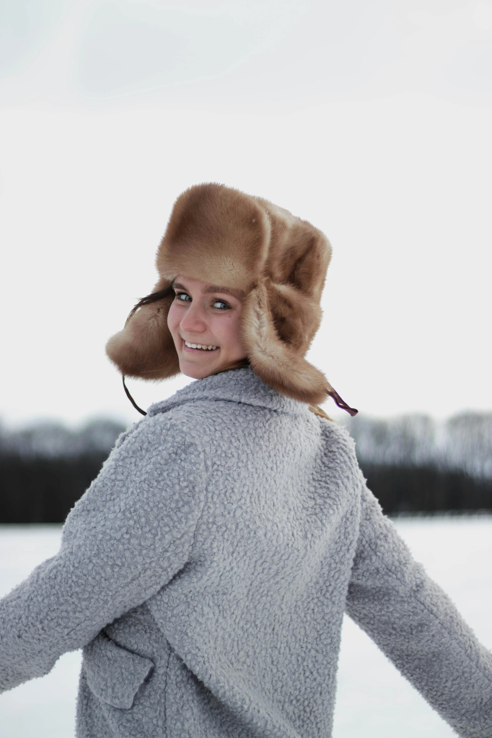 a young woman is in the snow and she is wearing a hat