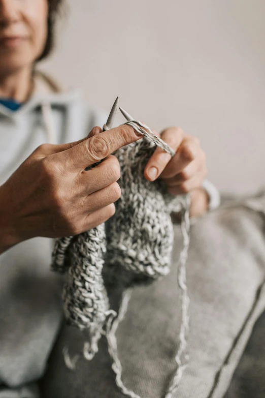 a person holding onto the end of a yarn ball and hook