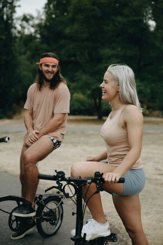 man and woman sitting next to a bicycle