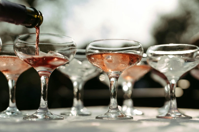 a row of glasses filled with various wines