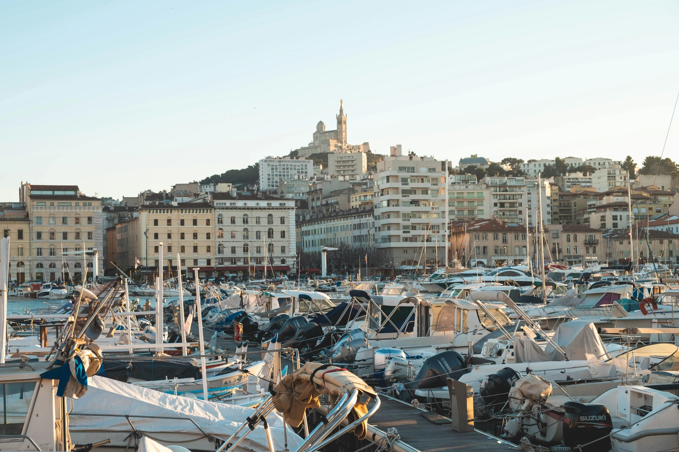 many boats docked in a harbor next to many large buildings