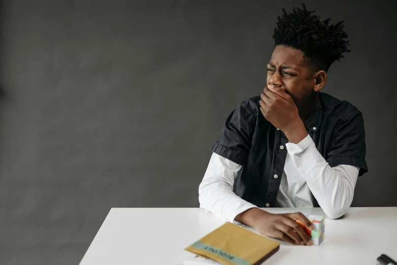 an african american sits at a desk and looks over his shoulder